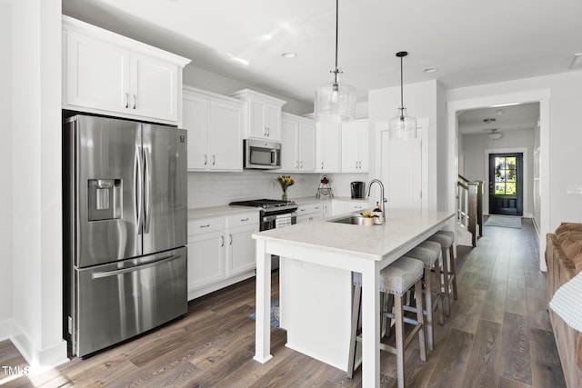 kitchen with recessed lighting, white cabinetry, a sink, backsplash, and stainless steel appliances