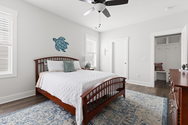 bedroom with baseboards, ceiling fan, and dark wood-type flooring