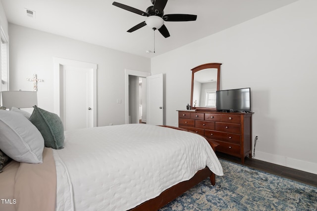 bedroom featuring a ceiling fan, baseboards, visible vents, and dark wood-style floors