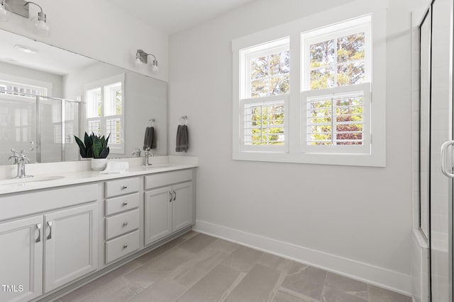 full bath with a sink, a shower with door, and a wealth of natural light