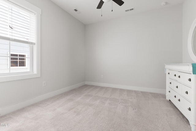 unfurnished bedroom featuring visible vents, baseboards, light carpet, and multiple windows