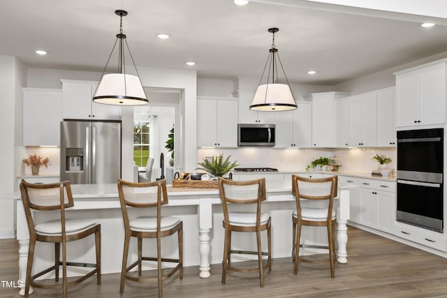 264 Alden Way, Angier, NC 27501 - kitchen featuring an island with sink, light countertops, appliances with stainless steel finishes, and white cabinets