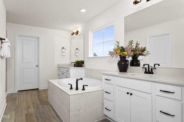 264 Alden Way, Angier, NC 27501 - bathroom featuring a garden tub, wood finished floors, recessed lighting, two vanities, and a sink