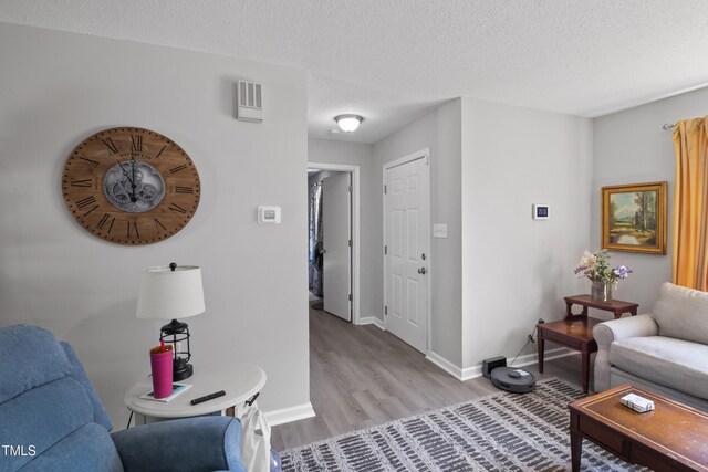 404 Creech St, Goldsboro, NC 27530 - living room with baseboards, a textured ceiling, and light wood-style flooring