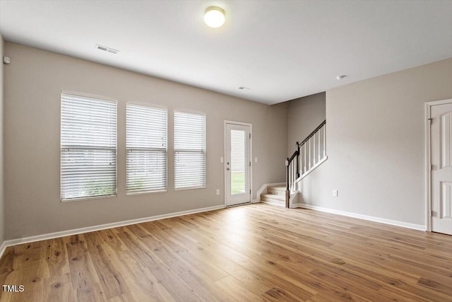 107 Tuftin Dr, Durham, NC 27703 - unfurnished living room with stairs and light wood-style floors