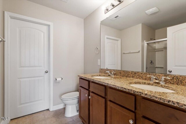 107 Tuftin Dr, Durham, NC 27703 - bathroom featuring a shower stall, double vanity, and tile patterned flooring