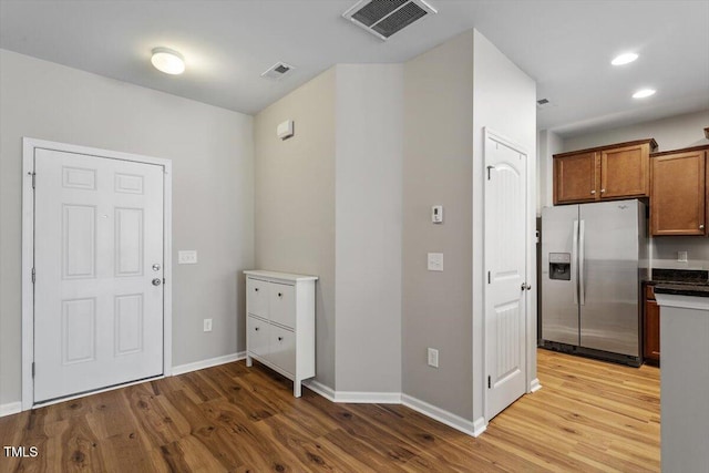 107 Tuftin Dr, Durham, NC 27703 - kitchen with stainless steel fridge with ice dispenser, light wood-type flooring, brown cabinetry, recessed lighting, and dark countertops
