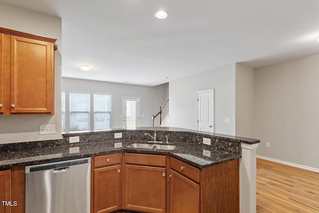 107 Tuftin Dr, Durham, NC 27703 - kitchen with stainless steel dishwasher, a peninsula, brown cabinetry, light wood-type flooring, and recessed lighting