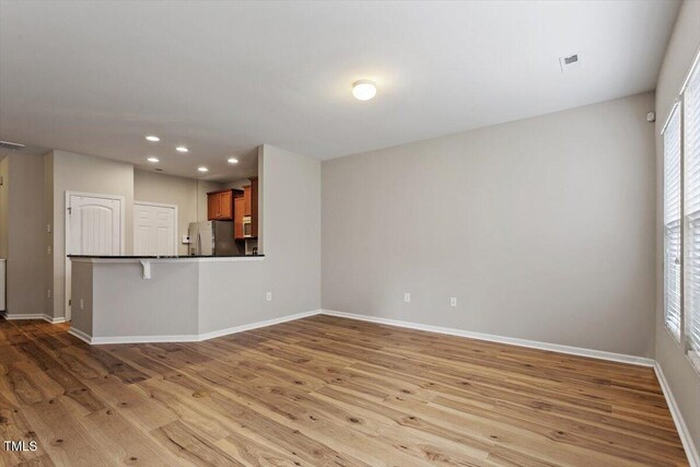 107 Tuftin Dr, Durham, NC 27703 - unfurnished living room featuring wood finished floors and recessed lighting