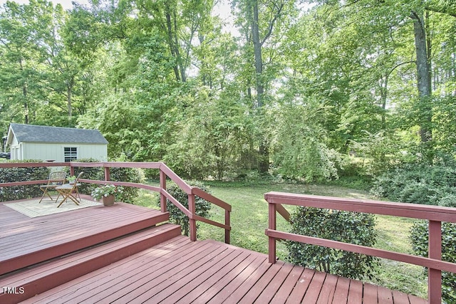 wooden deck featuring a storage unit, a view of trees, and an outbuilding