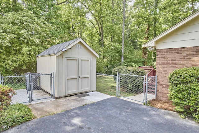 view of shed featuring fence and a gate