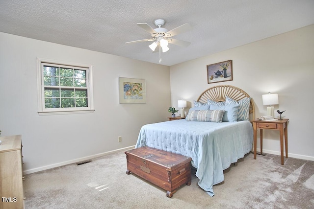 carpeted bedroom with baseboards, a ceiling fan, a textured ceiling, and visible vents