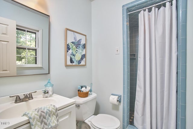full bath featuring vanity, toilet, and tiled shower