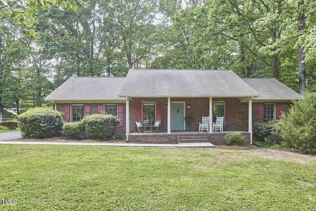 ranch-style home with covered porch, brick siding, and a front yard
