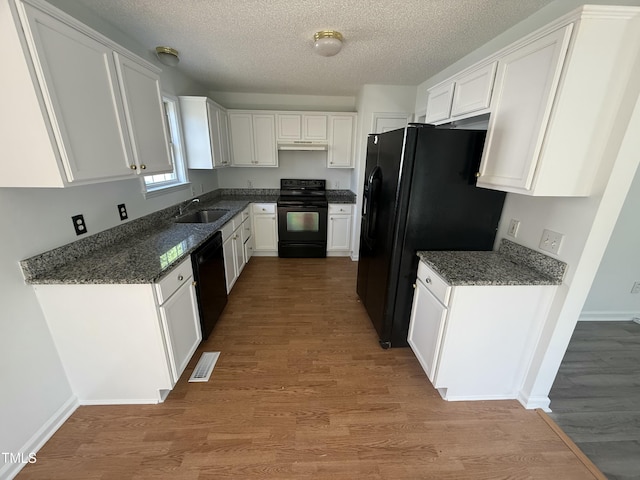 118 Hawthorn Dr, Clayton, NC 27520 - kitchen featuring a sink, light wood-style flooring, white cabinetry, and black appliances
