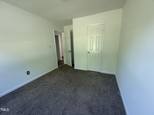 118 Hawthorn Dr, Clayton, NC 27520 - unfurnished bedroom featuring a textured ceiling, baseboards, and dark carpet