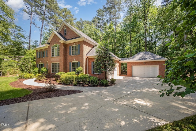 8840 Woodyhill Rd, Raleigh, NC 27613 - view of front of property featuring brick siding, a garage, and concrete driveway