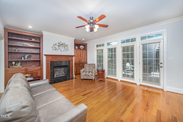 8840 Woodyhill Rd, Raleigh, NC 27613 - living area featuring crown molding, ceiling fan, light wood-style floors, a fireplace, and baseboards