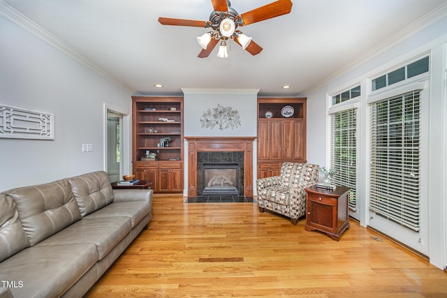8840 Woodyhill Rd, Raleigh, NC 27613 - living room featuring light wood-style flooring, ornamental molding, a fireplace, healthy amount of natural light, and ceiling fan
