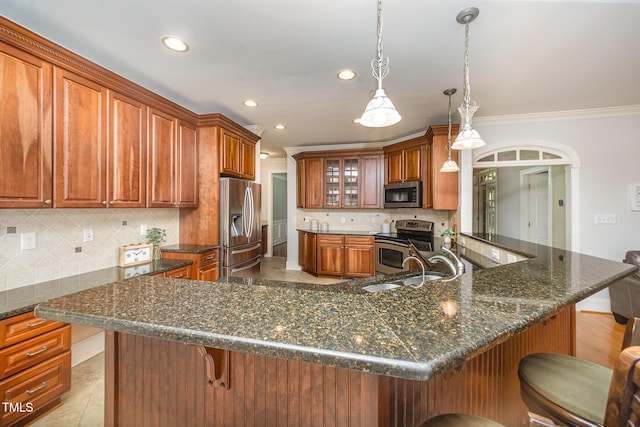 8840 Woodyhill Rd, Raleigh, NC 27613 - kitchen featuring stainless steel appliances, a breakfast bar area, recessed lighting, brown cabinetry, and crown molding