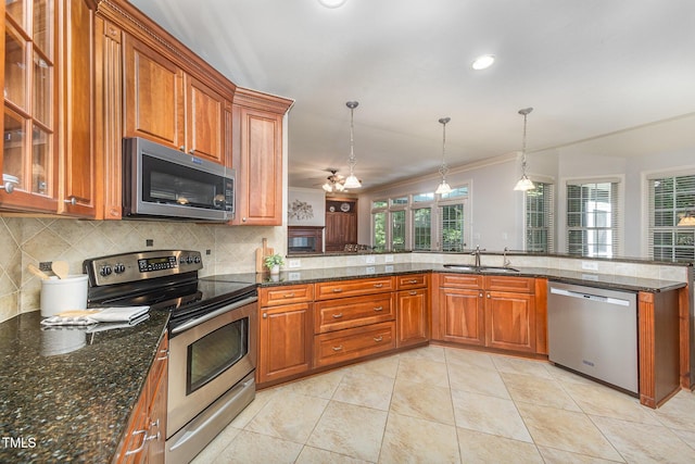 8840 Woodyhill Rd, Raleigh, NC 27613 - kitchen featuring appliances with stainless steel finishes, a sink, brown cabinets, backsplash, and crown molding