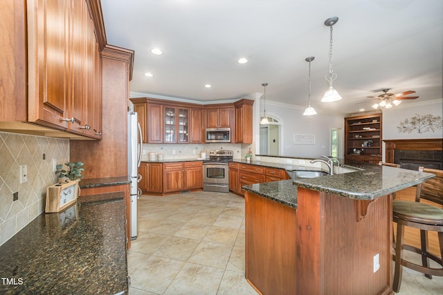 8840 Woodyhill Rd, Raleigh, NC 27613 - kitchen featuring appliances with stainless steel finishes, a sink, a peninsula, brown cabinets, and crown molding