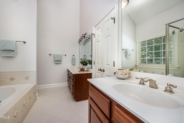 8840 Woodyhill Rd, Raleigh, NC 27613 - full bathroom with two vanities, a garden tub, a shower stall, and tile patterned flooring