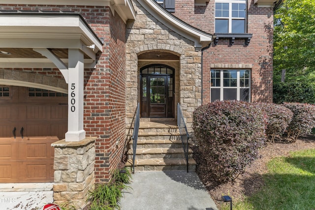 property entrance featuring brick siding, a garage, and stone siding