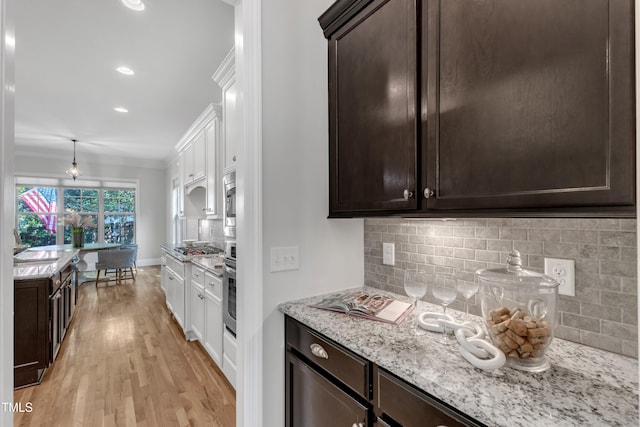 kitchen with backsplash, dark brown cabinets, and ornamental molding