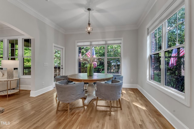dining area featuring baseboards, ornamental molding, and light wood-style flooring