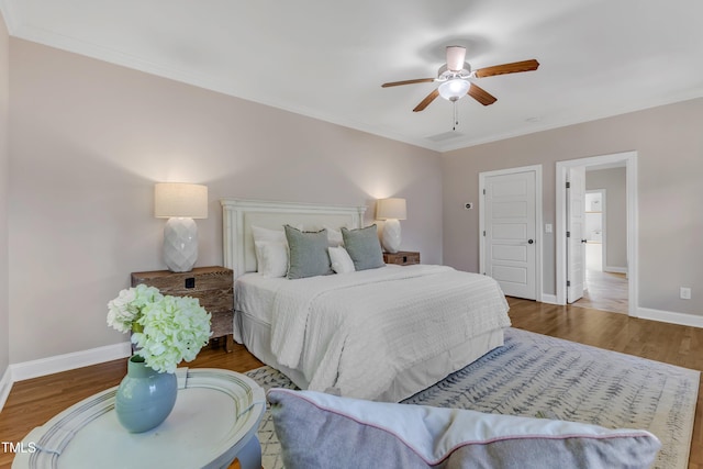 bedroom featuring baseboards, ornamental molding, a ceiling fan, and wood finished floors