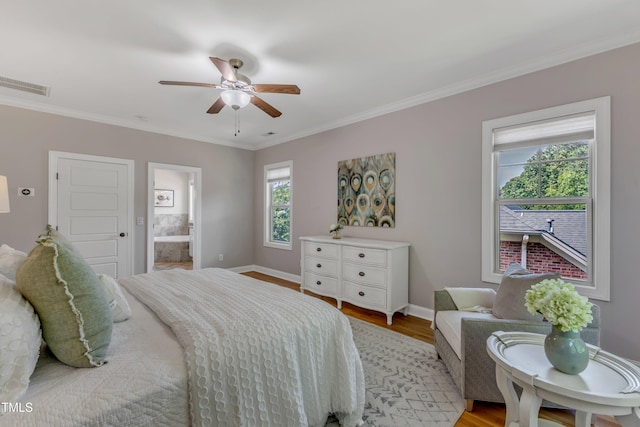 bedroom featuring crown molding, baseboards, light wood finished floors, and visible vents