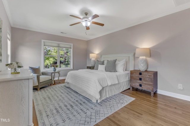 bedroom featuring a ceiling fan, baseboards, visible vents, and light wood finished floors