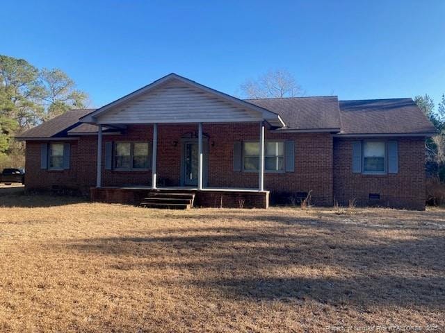 ranch-style home with covered porch, a front yard, crawl space, and brick siding