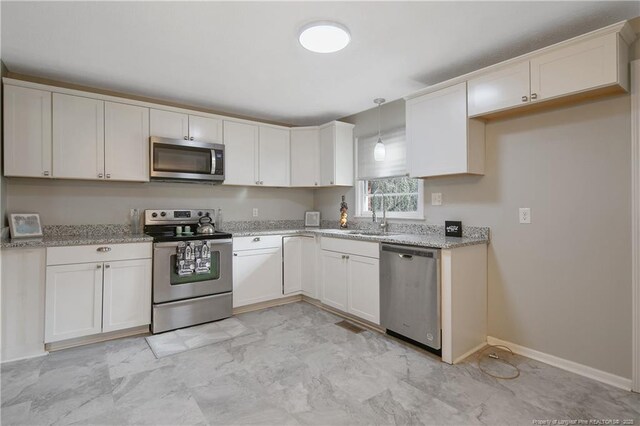 6019 S US Highway 301, Hope Mills, NC 28348 - kitchen with hanging light fixtures, appliances with stainless steel finishes, a sink, light stone counters, and baseboards