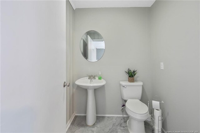 6019 S US Highway 301, Hope Mills, NC 28348 - half bathroom featuring toilet, baseboards, and a sink