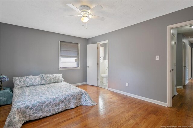 6019 S US Highway 301, Hope Mills, NC 28348 - bedroom featuring baseboards, ceiling fan, ensuite bath, and wood finished floors