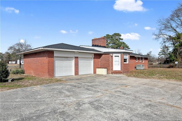6019 S US Highway 301, Hope Mills, NC 28348 - view of property exterior featuring a garage, a chimney, driveway, and brick siding