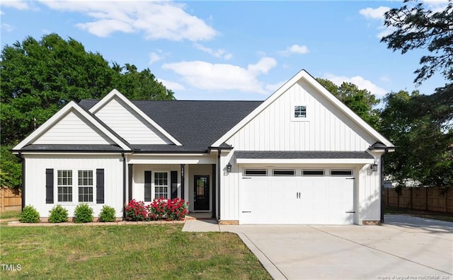 186 N Ashe Ave, Dunn, NC 28334 - view of front facade with fence, roof with shingles, a front lawn, a garage, and driveway