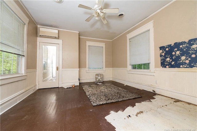 236 E Andrews Ave, Henderson, NC 27536 - unfurnished room with visible vents, wood-type flooring, ornamental molding, a wall mounted air conditioner, and a wainscoted wall
