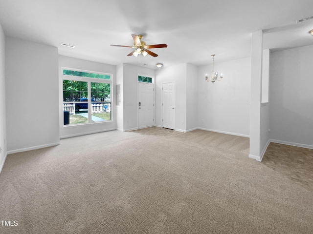 unfurnished living room with carpet floors, baseboards, visible vents, and ceiling fan with notable chandelier