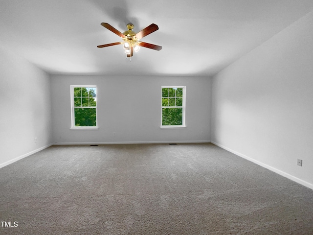 carpeted spare room with baseboards and ceiling fan