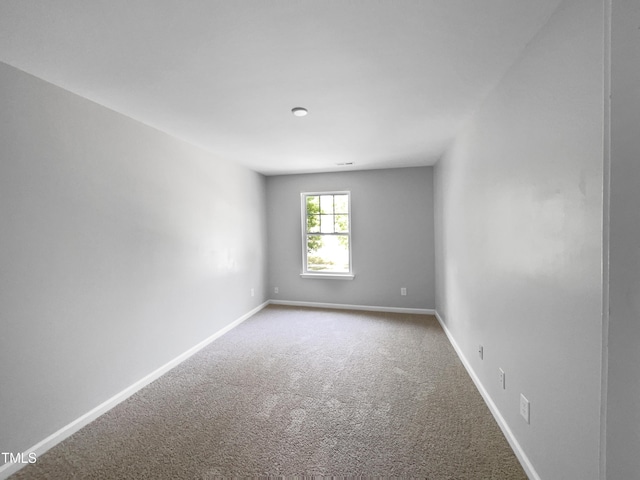 spare room featuring baseboards and carpet