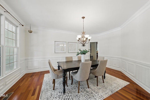 dining room featuring an inviting chandelier, ornamental molding, and dark wood-style floors