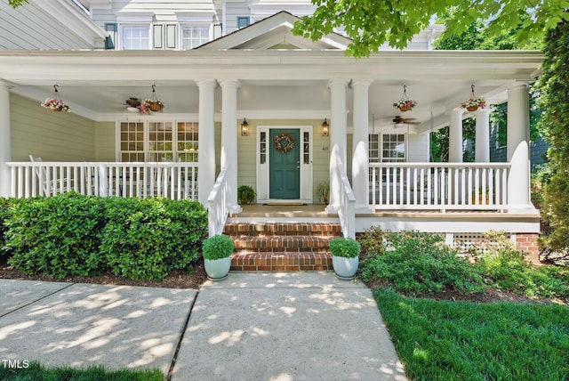 view of exterior entry with a porch, a ceiling fan, and a chimney