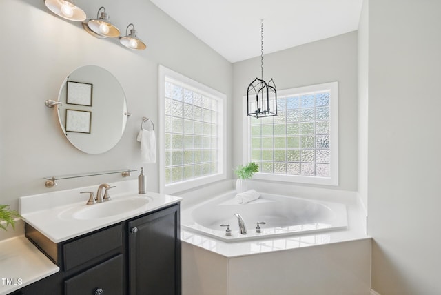 full bathroom featuring vanity, a garden tub, and an inviting chandelier