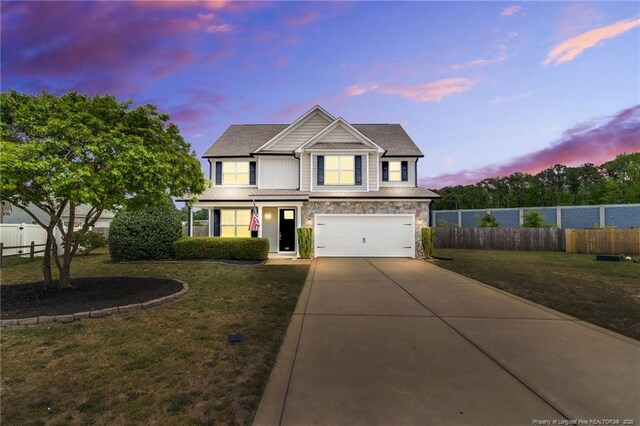 view of front of property with a garage, a yard, fence, and driveway