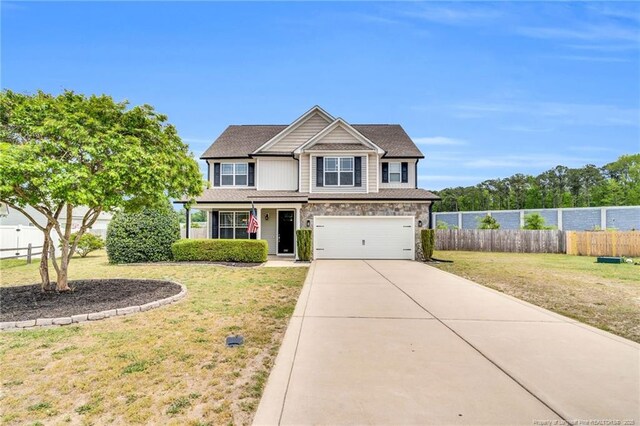 view of front of home with fence, an attached garage, driveway, and a front lawn