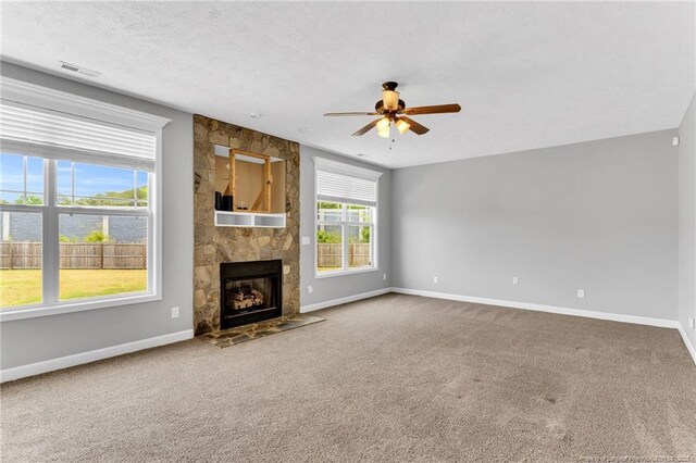 unfurnished living room featuring carpet flooring, ceiling fan, visible vents, and baseboards