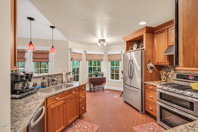 11 Bridgeport Dr, Durham, NC 27713 - kitchen featuring appliances with stainless steel finishes, brown cabinets, a sink, brick floor, and under cabinet range hood